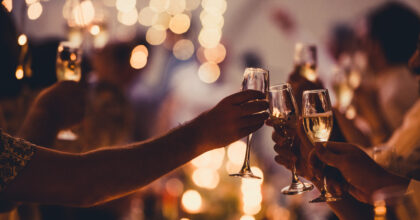 Numerous hands holding champagne flutes with champagne celebratory toast silhouettes